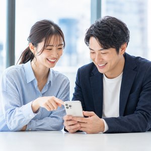 スマホを一緒に見るカップル